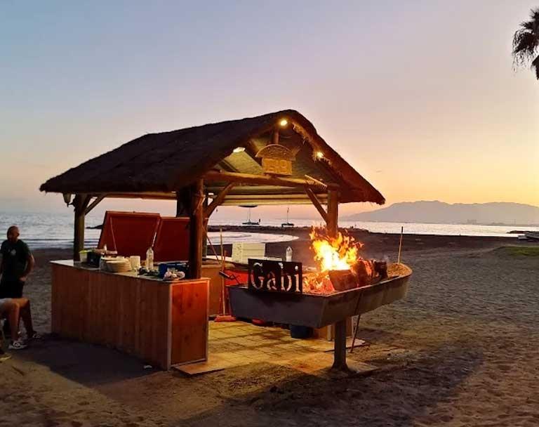 Barca de espetos del Restaurante Gabi al atardecer en El Palo